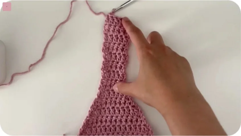 First tapered strap of a pink crochet mesh tote